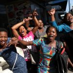 Zimbabweans celebrate in the morning sun after President Mugabe resigned in Harare