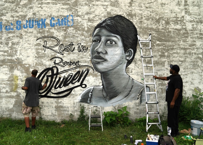 A man paints a mural of Aretha Franklin on a wall down the street where the Rev. Jesse Jackson spoke celebrating the life of singer Aretha Franklin at her father's church