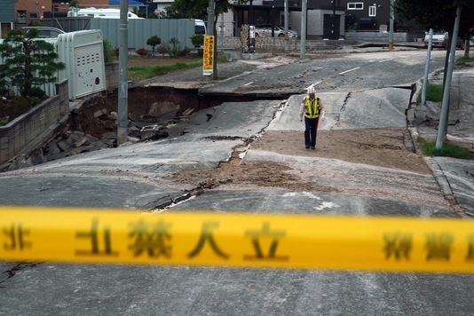A security guard walks on an earthquake-damaged street in Kiyota, outskirts of Sapporo city