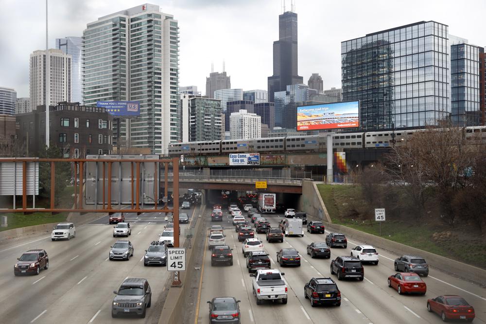 traffic flows along Interstate 90 highway as a Metra suburban commuter train