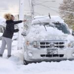 Taylor Olson clears snow from her car