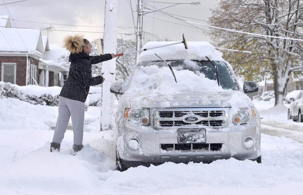 Taylor Olson clears snow from her car 