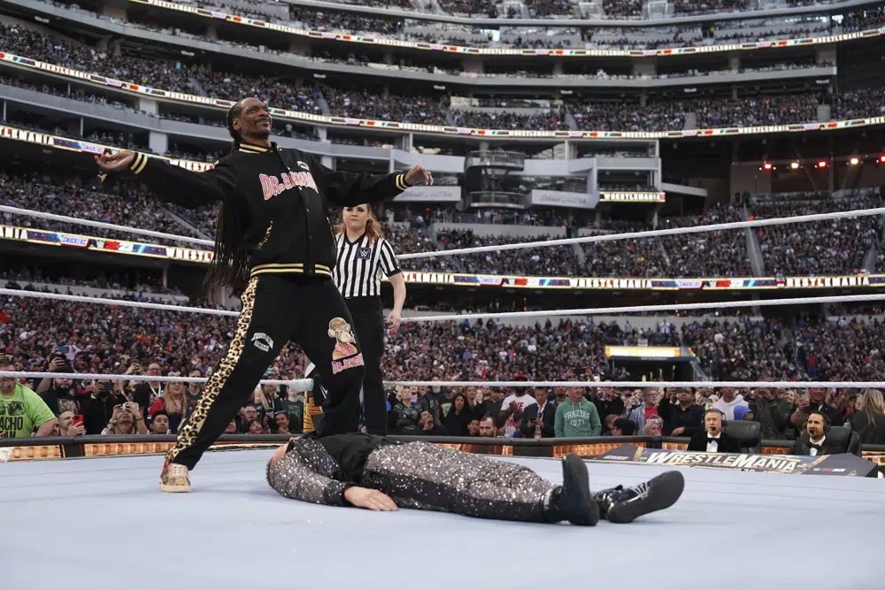 In this photo provided by WWE, rapper Snoop Dogg gets ready to drop The People's Elbow on Mike "The Miz" Mizanin during WrestleMania 39 on Sunday, April 2, 2023, at SoFi Stadium in Inglewood, Calif. 