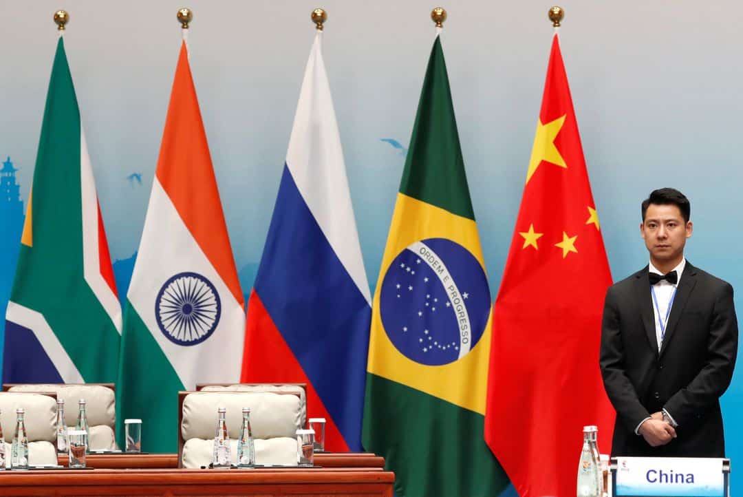 An attendant is stands next to South African, Indian, Russian, Brazilian and Chinese flags during a plenary session of BRICS Summit, in Xiamen, China September 4, 2017. REUTERS/Tyrone Siu