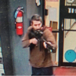 A man identified as a suspect by police points what appears to be a semiautomatic rifle, in Lewiston, Maine, U.S.