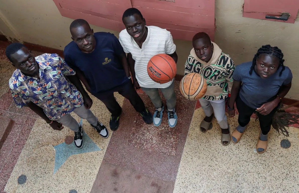 Mangok Bol, an American who resettled in the U.S. decades ago, poses for a photograph with his nieces and nephews, South Sudanese refugees Thon Makech Mach 21, Magot Makech Mach 18, Ajoh Makech Mach 15 and Makuei Makech Mach 11, as he plans to bring them to join him, at their rented apartment in Zimmerman, Kasarani district of Nairobi, Kenya December 15, 2023. REUTERS/Thomas Mukoya