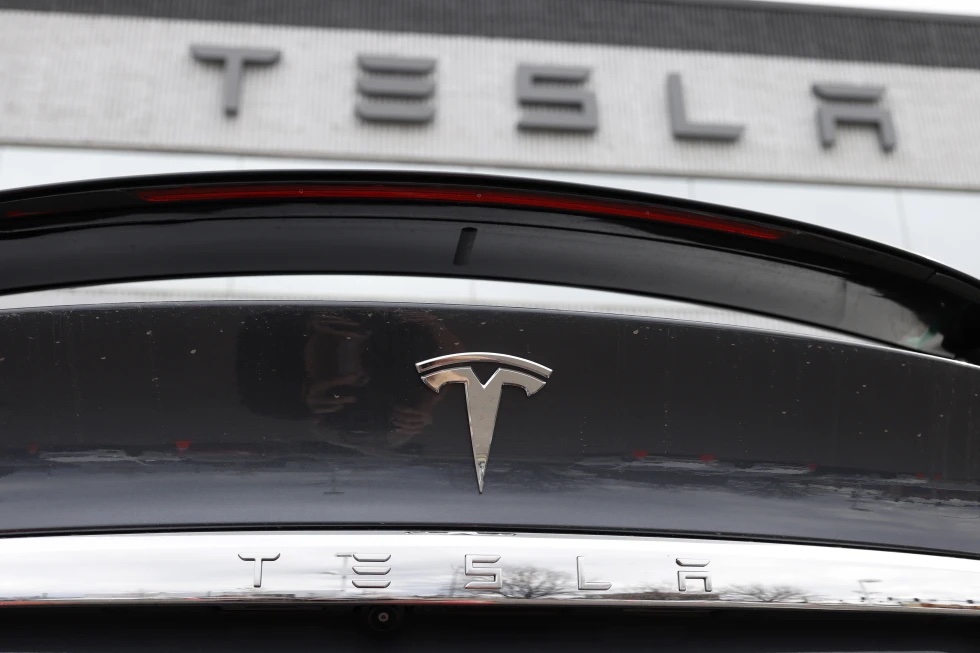 The Tesla company logo shines off the rear deck of an unsold 2020 Model X at a Tesla dealership, April 26, 2020, in Littleton, Colo. 