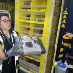 A worker moves a package at an Amazon same-day delivery shipping center in Woodland Park