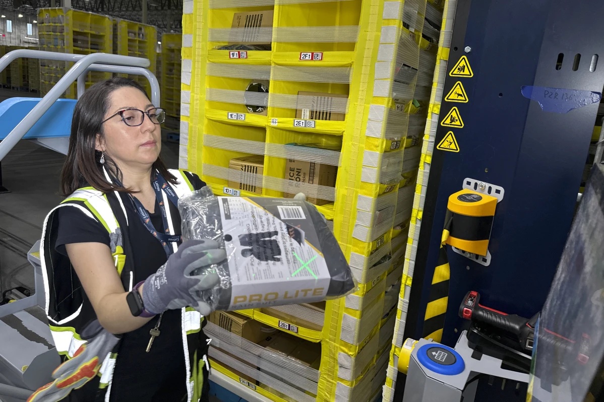 A worker moves a package at an Amazon same-day delivery shipping center in Woodland Park