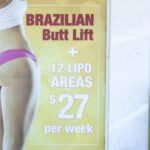 A window display advertises low-cost “Brazilian butt lift” cosmetic surgery procedures outside a clinic in Miami on Friday, March 22, 2019.