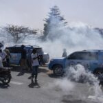 Senegalese riot police lobs tear gas at supporters of opposition presidential candidate Daouda Ndiaye in Dakar, Senegal, Sunday, Feb. 4, 2024. West Africa’s regional bloc on Sunday called for dialogue to resolve the political crisis in Senegal as opposition leaders rejected the decision by the country’s leader to postpone the Feb. 25 presidential election over an electoral dispute between parliament and the judiciary. (AP Photo/Stefan Kleinowitz)