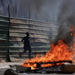 A boy runs past barricades as Senegalese demonstrators clash with riot police during a protest against the postponement of the Feb. 25 presidential election, in Dakar, Senegal February 4, 2024. REUTERS/Zohra Bensemra