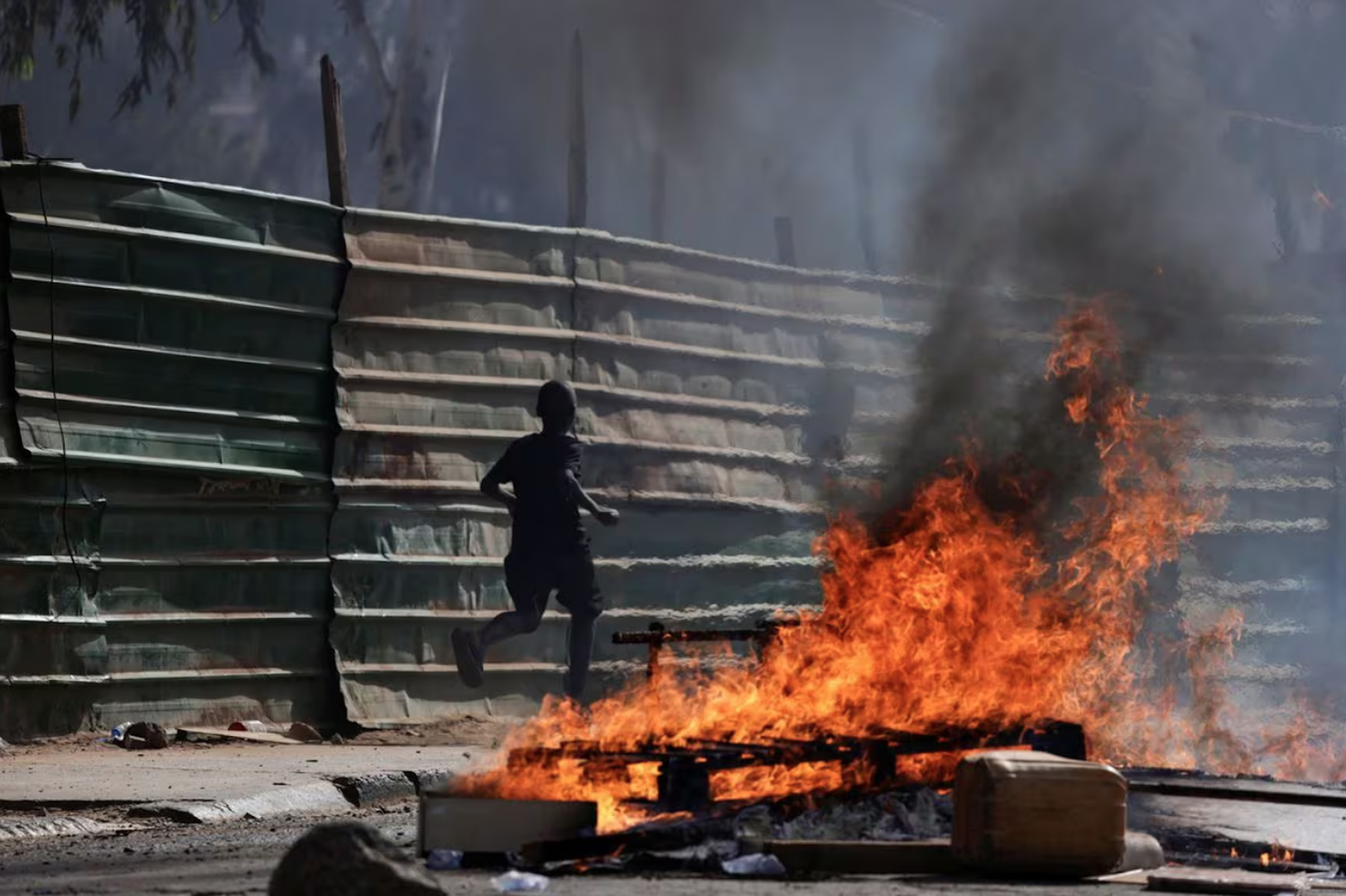 A boy runs past barricades as Senegalese demonstrators clash with riot police during a protest against the postponement of the Feb. 25 presidential election, in Dakar, Senegal February 4, 2024. REUTERS/Zohra Bensemra