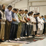 Coalition service members and civilian contractors participate in an Eid al-Fitr ceremony