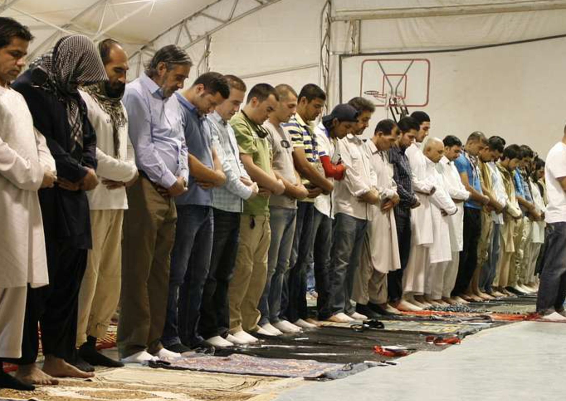 Coalition service members and civilian contractors participate in an Eid al-Fitr ceremony