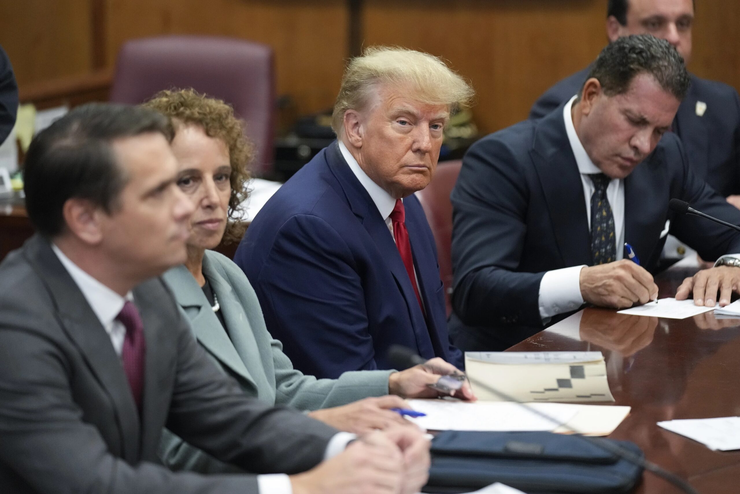Former President Donald Trump sits at the defense table with his legal team in a Manhattan court