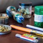 A selection of cannabis accessories, including a dab pen in the foreground.