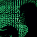 A man holds a laptop computer as cyber code is projected on him in this illustration picture taken on May 13, 2017. REUTERS/Kacper Pempel/Illustration/File Photo