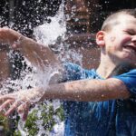 A boy cools off at a fountain