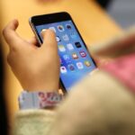A child holds an iPhone at an Apple store