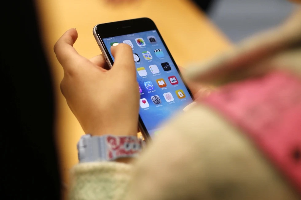 A child holds an iPhone at an Apple store