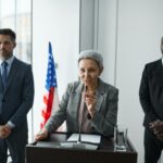 Woman giving speech with bodyguards behind her