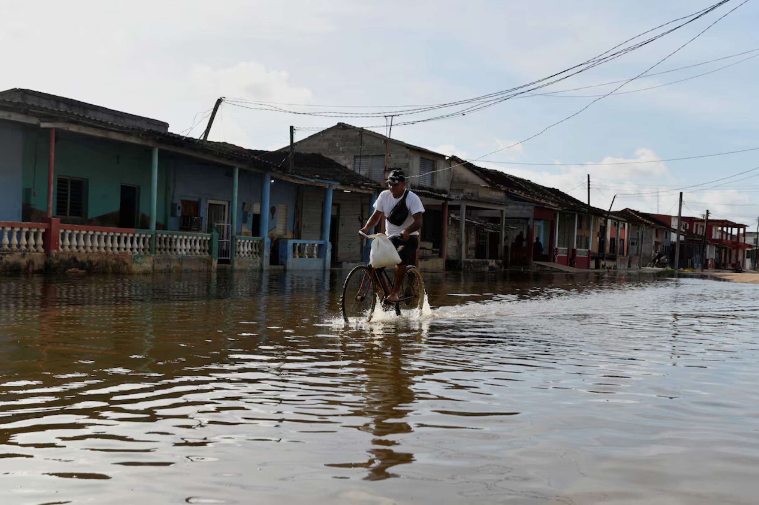 A man cycles through a flooded street as Hurricane Milton approaches the Cuban coast in Batabano, Cuba, October 8, 2024.