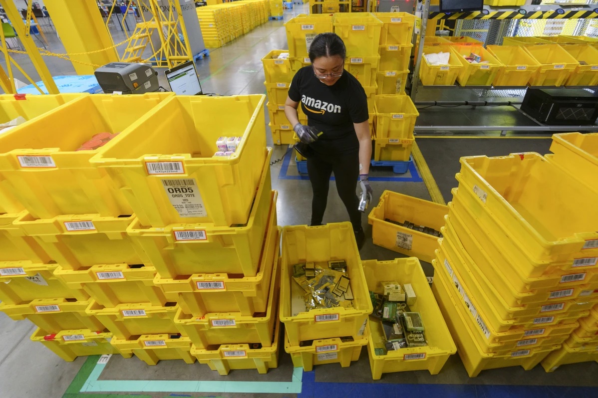 FILE - An employee scans incoming items at a receiving station at the Amazon OXR1 fulfillment center in Oxnard, Calif., on Aug. 21, 2024.