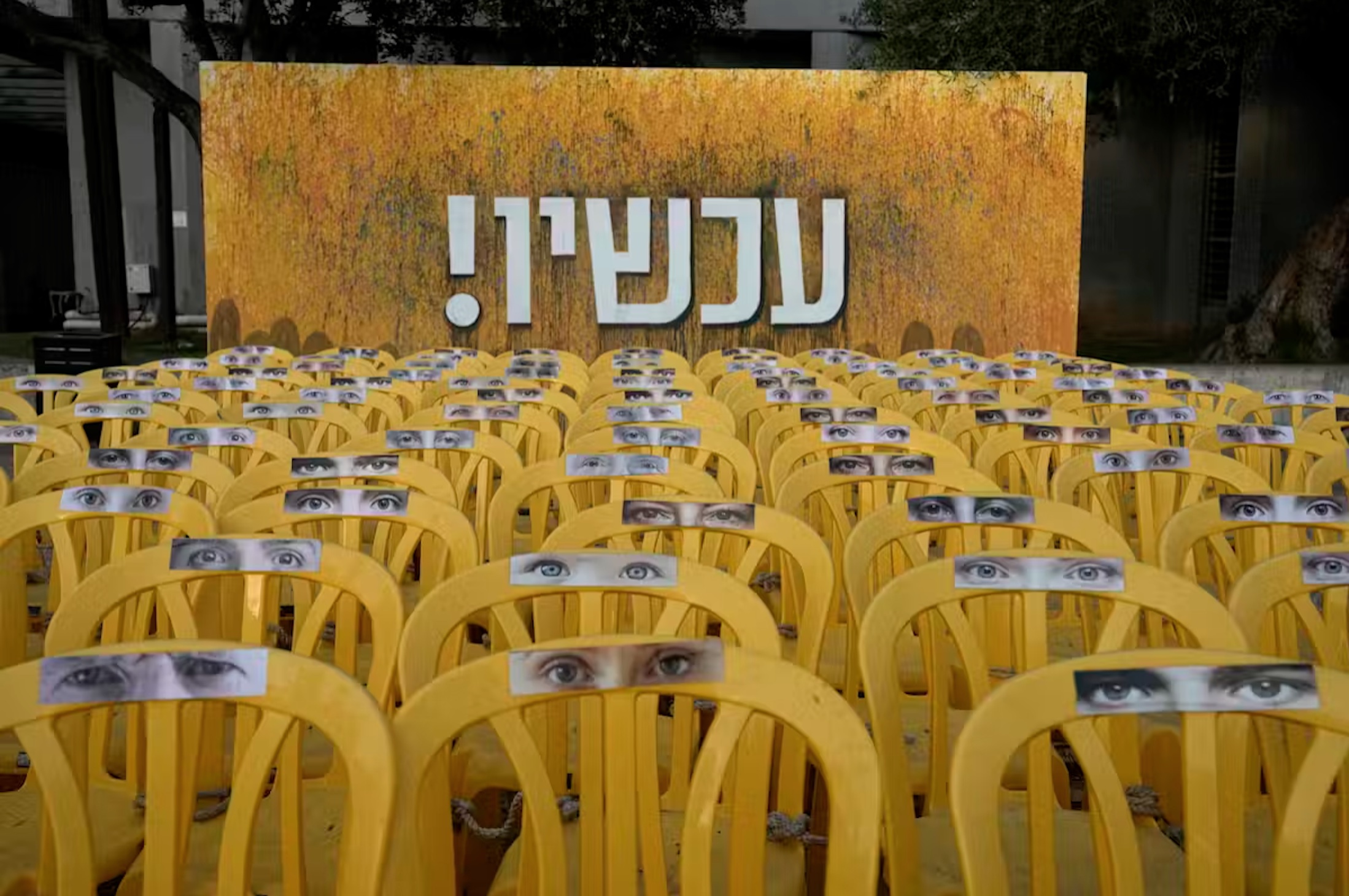 Chairs representing hostages held by Hamas militants in the Gaza Strip, displayed beneath the Hebrew word ‘Now!’ in Tel Aviv.