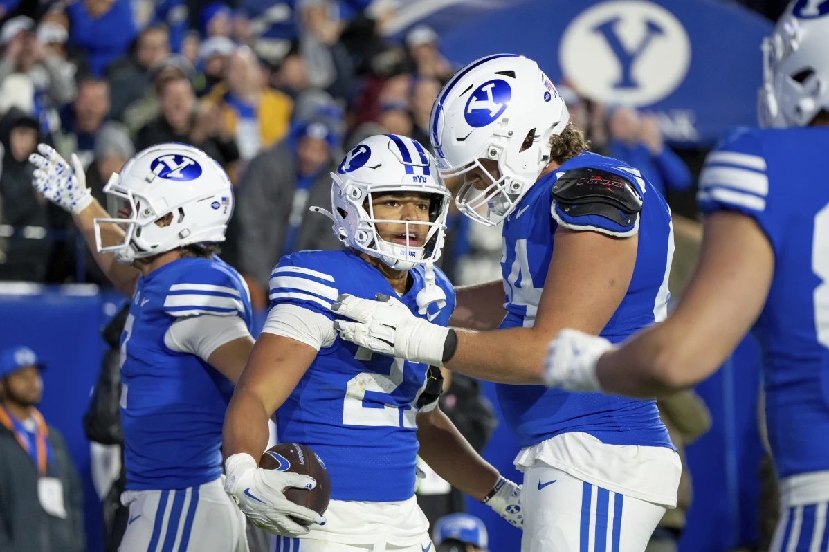BYU running back LJ Martin, second from left, celebrates after scoring a touchdown in the second half of an NCAA college football game against Oklahoma State, Friday, Oct. 18, 2024, in Provo, Utah.