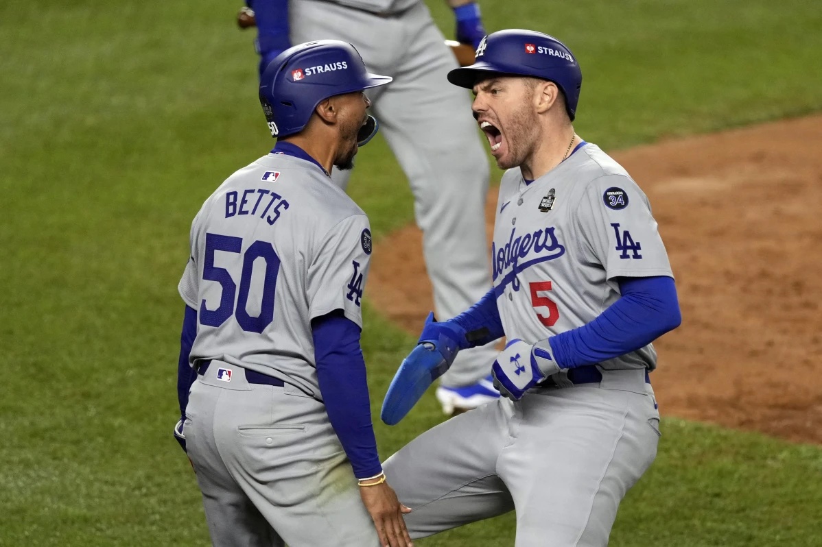 Los Angeles Dodgers’ Mookie Betts (50) and Freddie Freeman (5) celebrate after scoring against the New York Yankees during the fifth inning in Game 5 of the baseball World Series, Wednesday, Oct. 30, 2024, in New York.