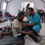 A health worker treats a patient with suspected bullet wounds at the CBCA Ndosho Hospital