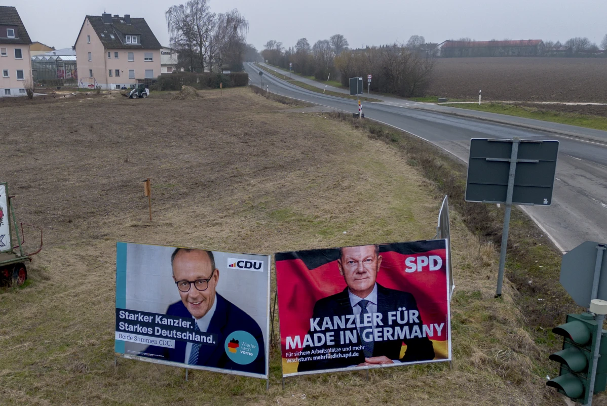 Election posters, showing German Chancellor Olaf Scholz, right, and CDU top candidate Friedrich Merz, stand on a meadow in Nieder-Erlenbach near Frankfurt, Germany, Feb. 5, 2025.