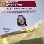 An image of former Canadian Olympic snowboarder Ryan Wedding, who is a fugitive and been charged with allegedly running and participating in a transnational drug trafficking operation, is displayed on a video monitor along with bricks of cocaine, foreground, during a news conference at the FBI offices in Los Angeles, Oct. 17, 2024.