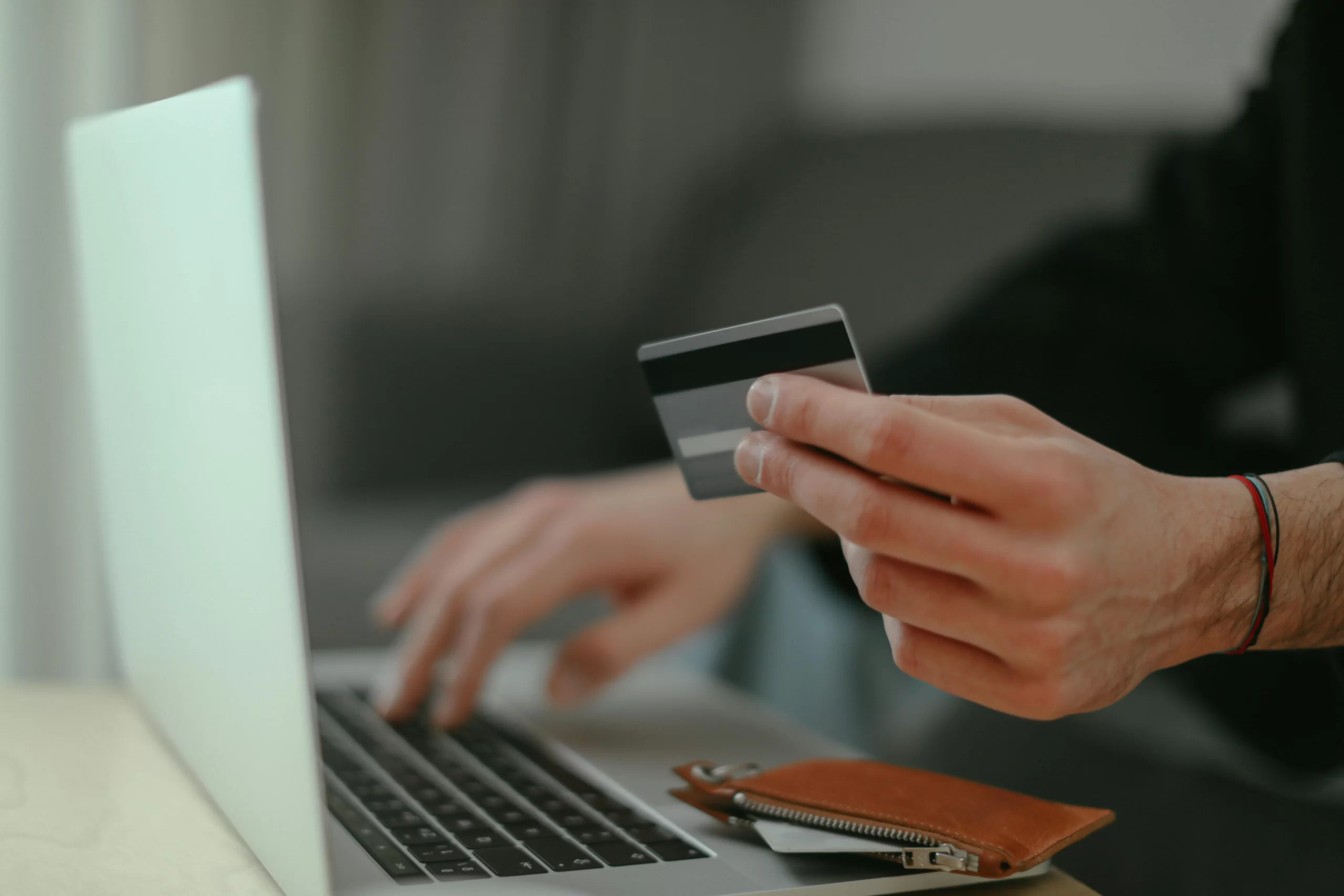 Close up of man hands using credit card online.