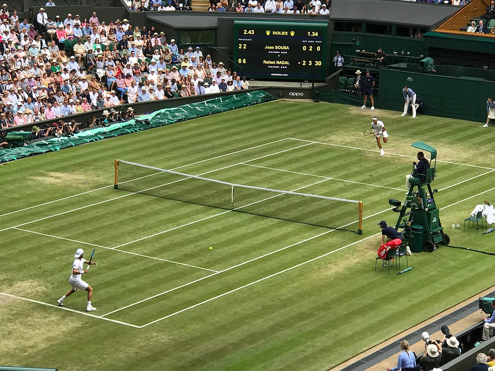 Rafael Nadal and Joao Sousa playing in set 3, game 6 of their match at the 2019 Wimbledon tennis tournament.