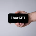 Hand holding smartphone with ChatGPT.