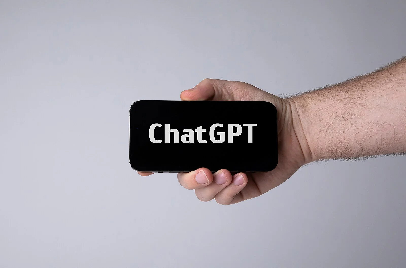 Hand holding smartphone with ChatGPT.