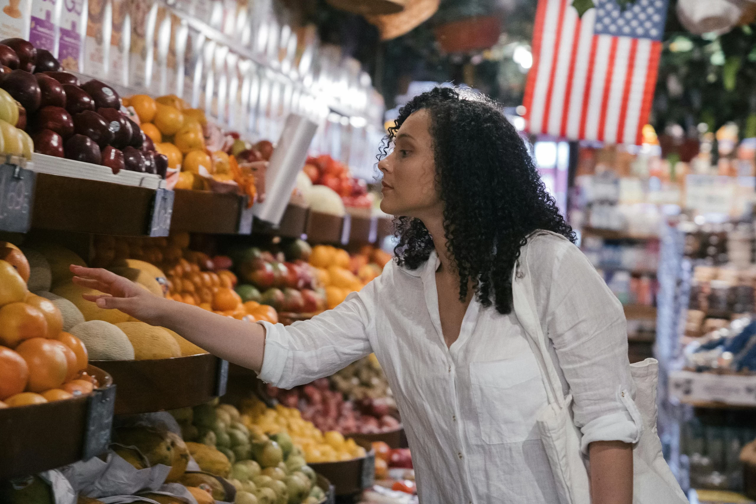A woman looking for vegetables and fruits inside the market.