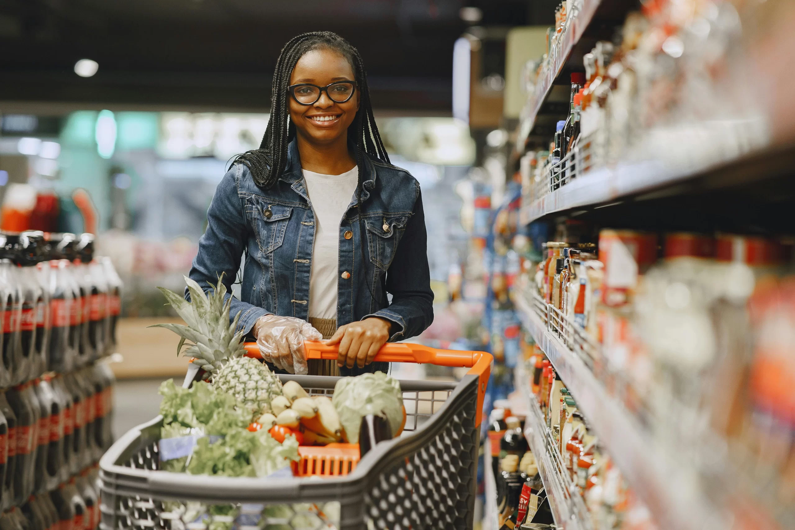A woman pushing a cart in a grocery store.