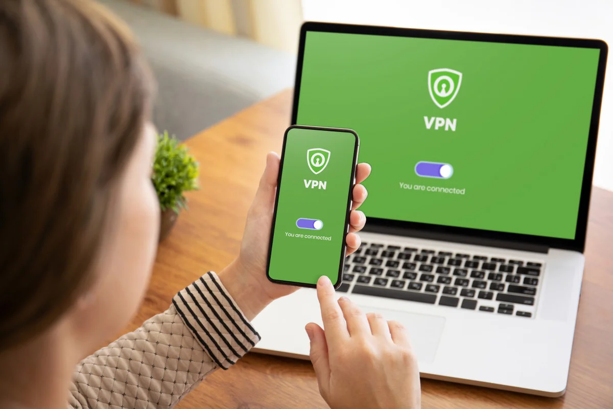 A Woman activating VPN on her computer and phone.