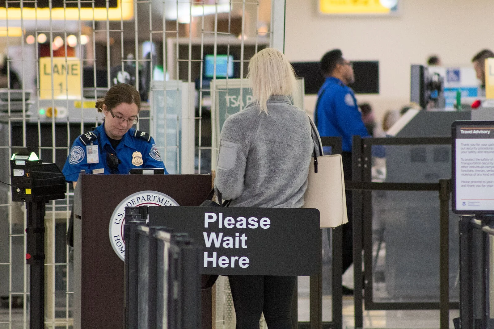A Transportation Security Administration agent at a checkpoint verifying passenger identification, John Glenn Columbus International Airport.