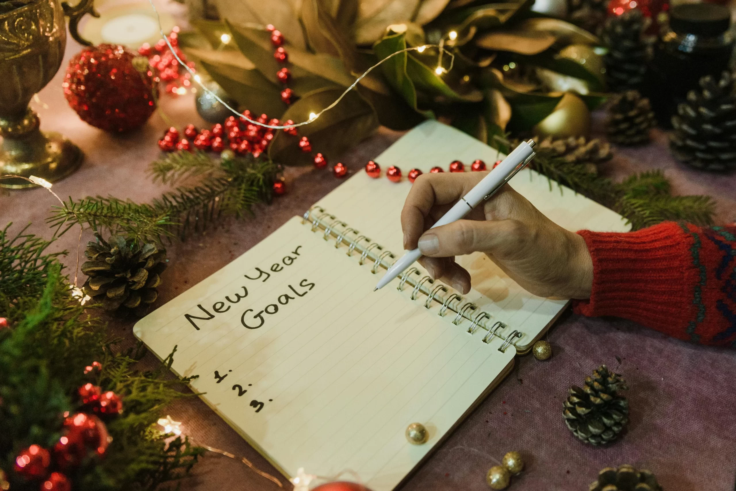A person writing a list of New Year resolutions.