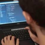 A developer coding on a laptop.