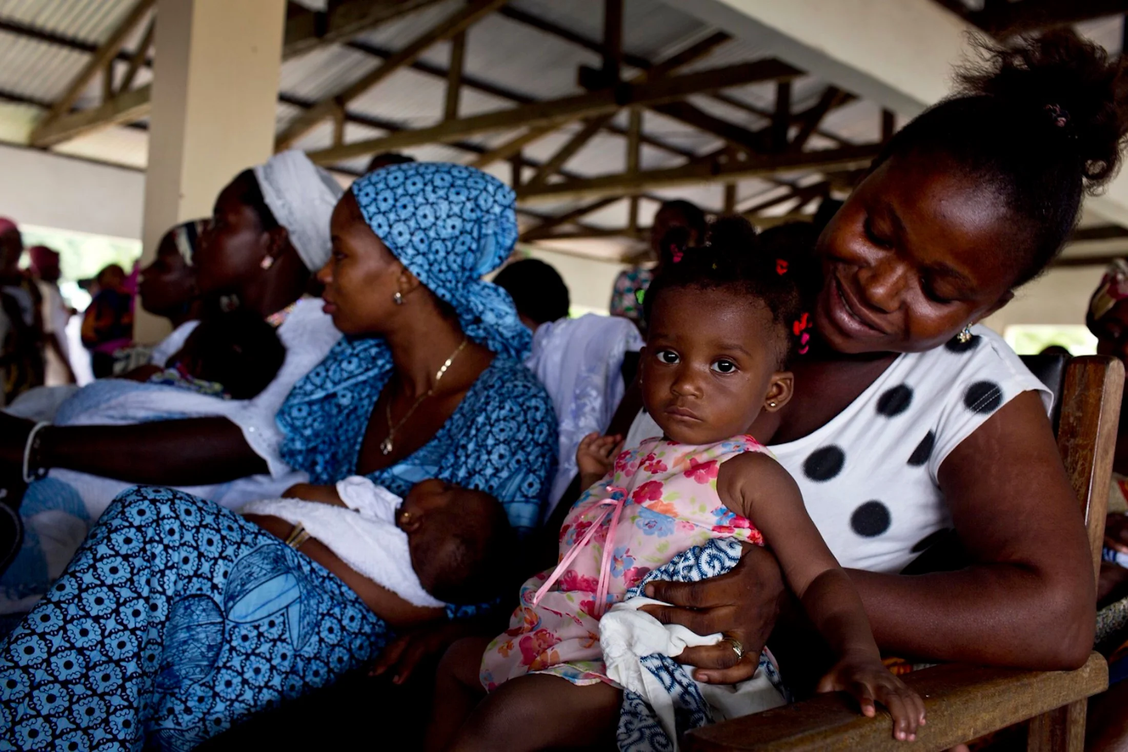Mothers wait to see midwives and health workers to weigh and vaccinate their children up to age five in a clinic in Accra, Ghana.