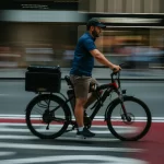 New York Delivery worker riding an E-bike on a street.