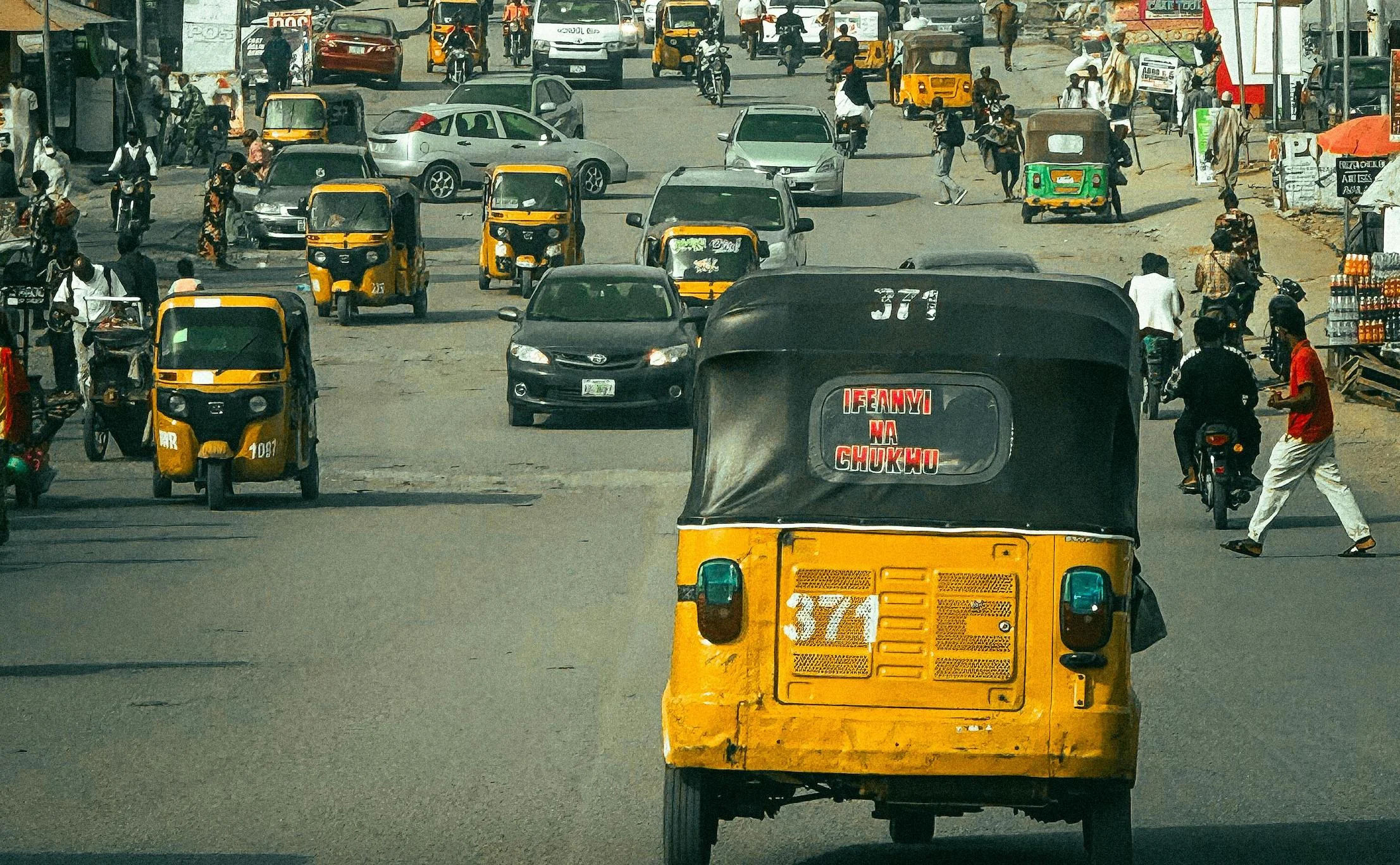 Bustling Nigerian street with keke napeps.