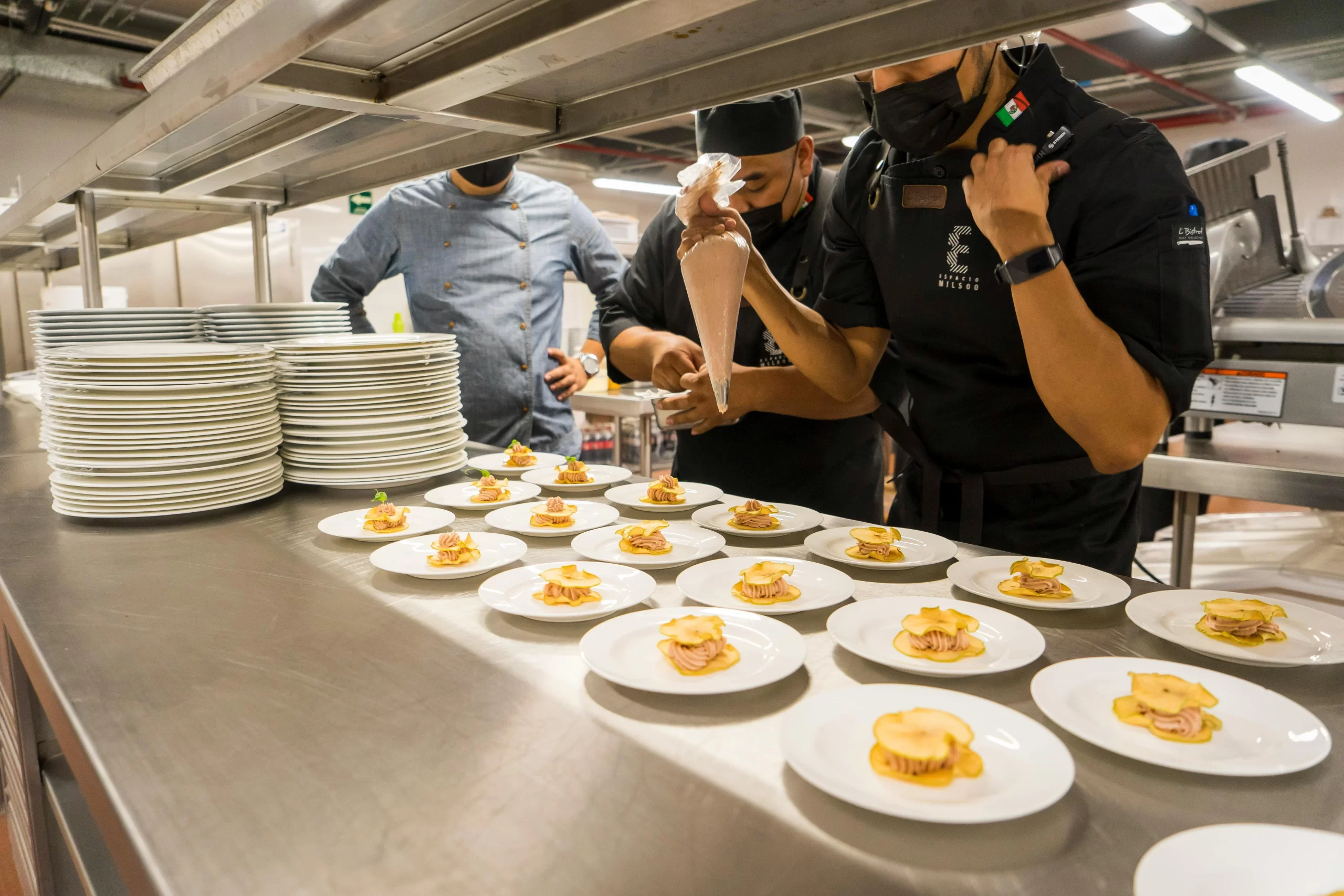 Food on Plates in a Kitchen by Chefs.
