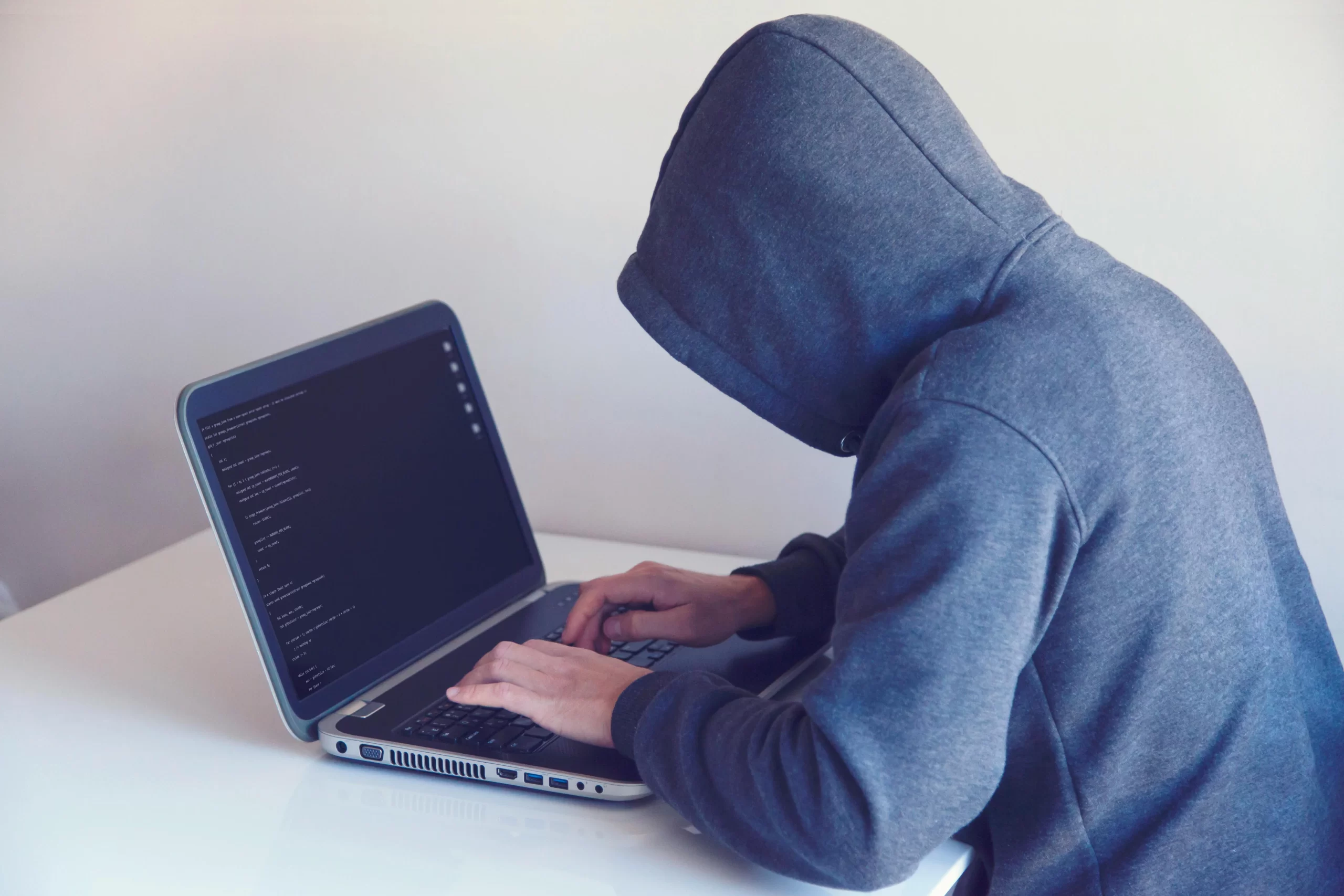 A person in a hoodie using a laptop