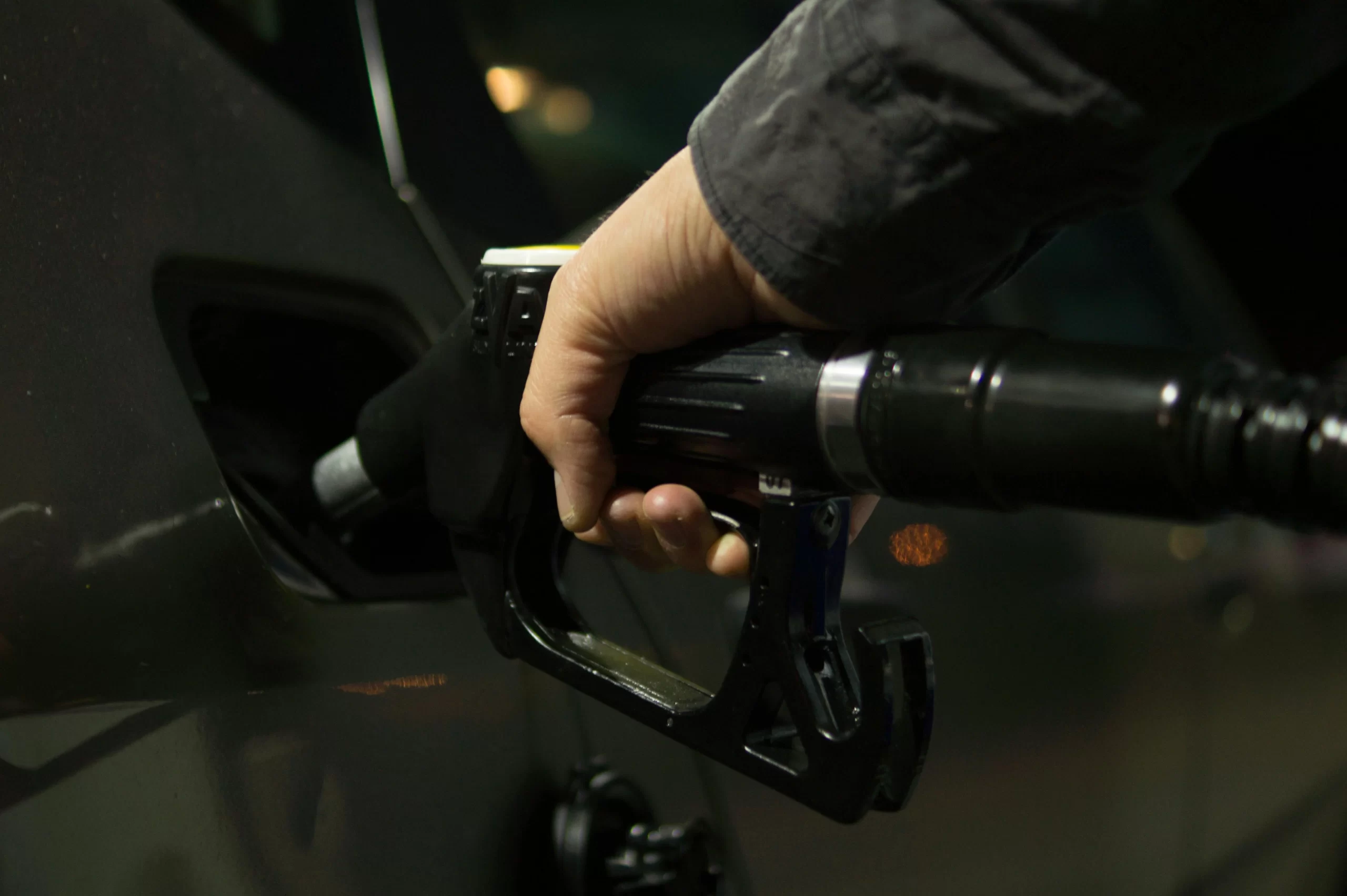 A person refueling a car at a gas pump.